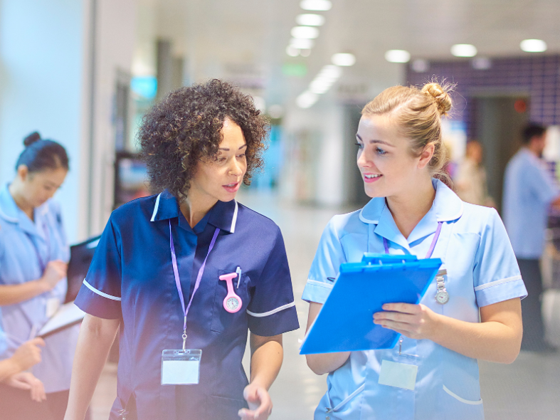 Two nurses looking at a clipboard