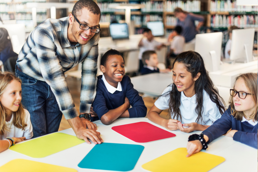 Teacher at a table with 4 students